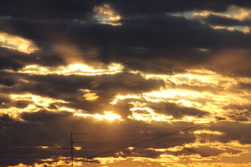 Wall Mural - the suns rays pass through the dark clouds. beautiful dramatic sky at sunset or sunrise.
