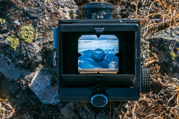 Wall Mural - look at the mountain scenery through the viewfinder of an old camera