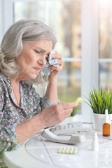 Close up portrait of sick senior woman with pills