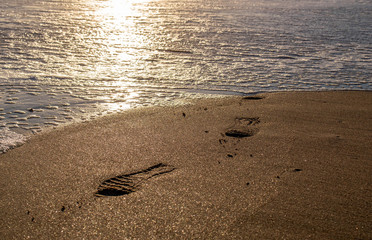 footprint erased in the sand with water