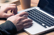 © ivanchik29 - Man typing on laptop keyboard, wooden table
