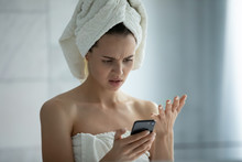 Frustrated Young Woman After Shower Stand In Bathroom Having Problems Using Smartphone Gadget, Disappointed Millennial Female Confused With Malfunction Virus Attack Or Spam On Cell