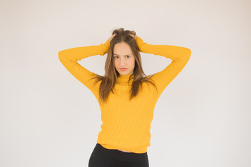 Beautiful young girl with yellow shirt is frustrated