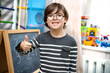© sushytska - Studying at home. The kid learns to count numbers on the board. Portrait of a cute happy school child boy at home doing homework. Primary school and education.