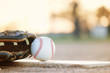 © ccestep8 - Baseball glove and ball on park sport field at sunset close up, copy space on blurred background.