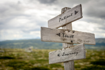 Sticker - patient, trust and journey text on wooden signpost outdoors in nature.