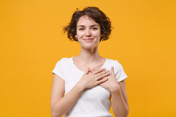 smiling young brunette woman girl in white t-shirt posing isolated on yellow orange wall background 