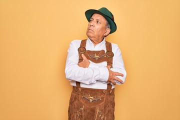 Sticker - Senior grey-haired man wearing german traditional octoberfest suit over yellow background looking to the side with arms crossed convinced and confident