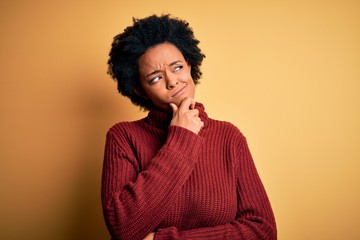 Young beautiful African American afro woman with curly hair wearing casual turtleneck sweater Thinking worried about a question, concerned and nervous with hand on chin