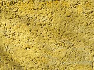 Wall Mural - Texture of a yellow rough stucco wall.