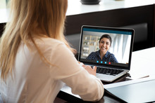 Laptop Screen View Over Female Shoulder, Businesswomen Working From Home On Common Project, Company Representative And Client Communication. Diverse Girls Friends Chat Via Video Conference Application