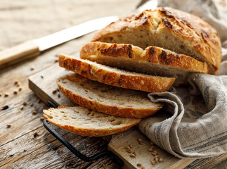 Homemade sourdough bread cut into slices on a wooden board, close up view