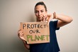 © Krakenimages.com - Young beautiful blonde woman with blue eyes asking for protect planet holding banner with angry face, negative sign showing dislike with thumbs down, rejection concept