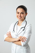 © Yakobchuk Olena - Cute smiling doctor posing for camera against light background