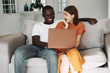© SHOTPRIME STUDIO - couple sitting on sofa with laptop computer