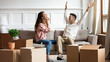 © fizkes - Full length happy married family couple sitting together in living room, laughing celebrating moving in new house. Overjoyed homeowners feeling excited about apartment flat mortgage purchase.