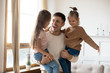 © fizkes - Overjoyed young father holding two little children siblings, having fun together at home, head shot. Excited dad playing with joyful adorable small daughter sisters, enjoying tender weekend moment.