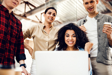 Wall Mural - Cheerful business colleagues using laptop at work