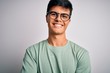 Young handsome man wearing casual t-shirt and glasses over isolated white background happy face smiling with crossed arms looking at the camera. Positive person.