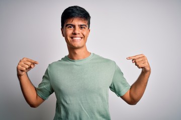 Sticker - Young handsome man wearing casual t-shirt standing over isolated white background looking confident with smile on face, pointing oneself with fingers proud and happy.