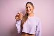 © Krakenimages.com - Young beautiful fitness woman drinking protein chocolate milkshake before gym with a happy face standing and smiling with a confident smile showing teeth