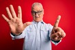 © Krakenimages.com - Middle age handsome hoary man wearing casual striped shirt and glasses over red background showing and pointing up with fingers number six while smiling confident and happy.