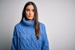 © Krakenimages.com - Young beautiful brunette woman wearing casual turtleneck sweater over white background Relaxed with serious expression on face. Simple and natural looking at the camera.