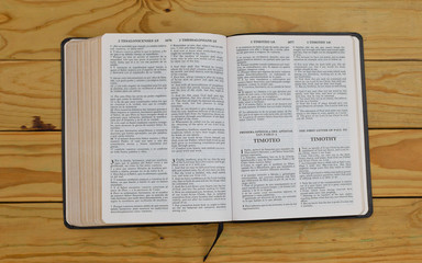 Wall Mural - open bilingual bible book on the fist letter of Paul to Timothy, Spanish and english 