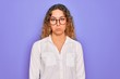 © Krakenimages.com - Young beautiful woman with blue eyes wearing casual shirt and glasses over purple background depressed and worry for distress, crying angry and afraid. Sad expression.