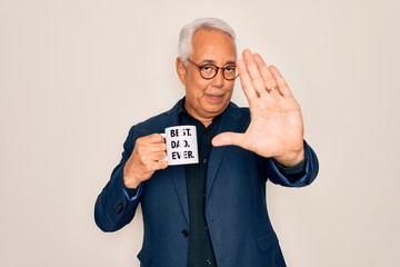 Sticker - Middle age senior grey-haired man drinking a coffee on best dad cup over isolated background with open hand doing stop sign with serious and confident expression, defense gesture