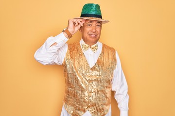 Canvas Print - Middle age senior grey-haired man wearing Brazilian carnival custome over yellow background worried and stressed about a problem with hand on forehead, nervous and anxious for crisis