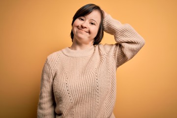 Sticker - Young down syndrome woman wearing casual sweater over yellow background confuse and wonder about question. Uncertain with doubt, thinking with hand on head. Pensive concept.