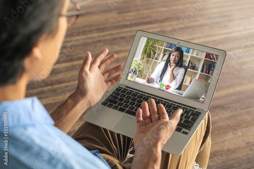 Fotomural Man video calling his psychologist to have a vistual session while in quarantine