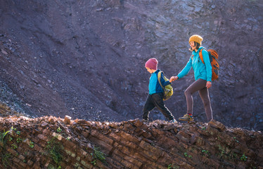 a boy with a backpack travels with his mother.