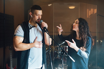 Wall Mural - a man does chanting with a teacher in vocal lesson pointing to the correct breathing in the chest