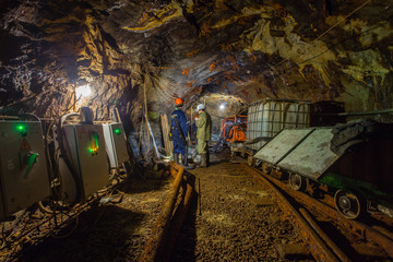 Miners at underground gold mine tunnel