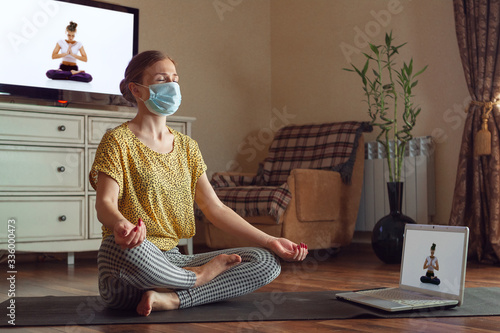 Fotografía Sporty young woman taking yoga lessons online and practice at home while being quarantine