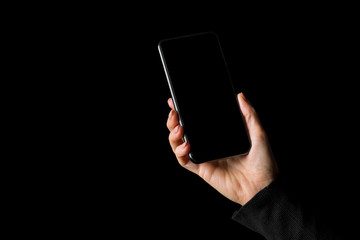 Person holding in hand mobile phone, isolated on black background