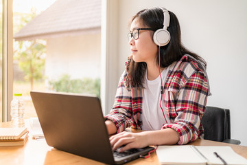 Young Asian female student working and studying from home