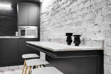 interior with stylish gray kitchen and white brick wall, modern kitchen design