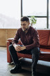 © Yevhenii Kukulka - A young man sits on the couch and talks about something