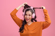 © vipubadee - Portrait of cute women with  headphones wearing orange  sweater on pink background. Beautiful happy asian girl look at camera; Free from copy space.