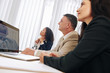 © DragonImages - Group of multi-ethnic business team watching presentation of colleague at meeting