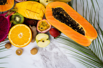 Exotic fruits and tropical leaves on table