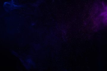 Wall Mural - blue and purple smoke and glitter on black, abstract background