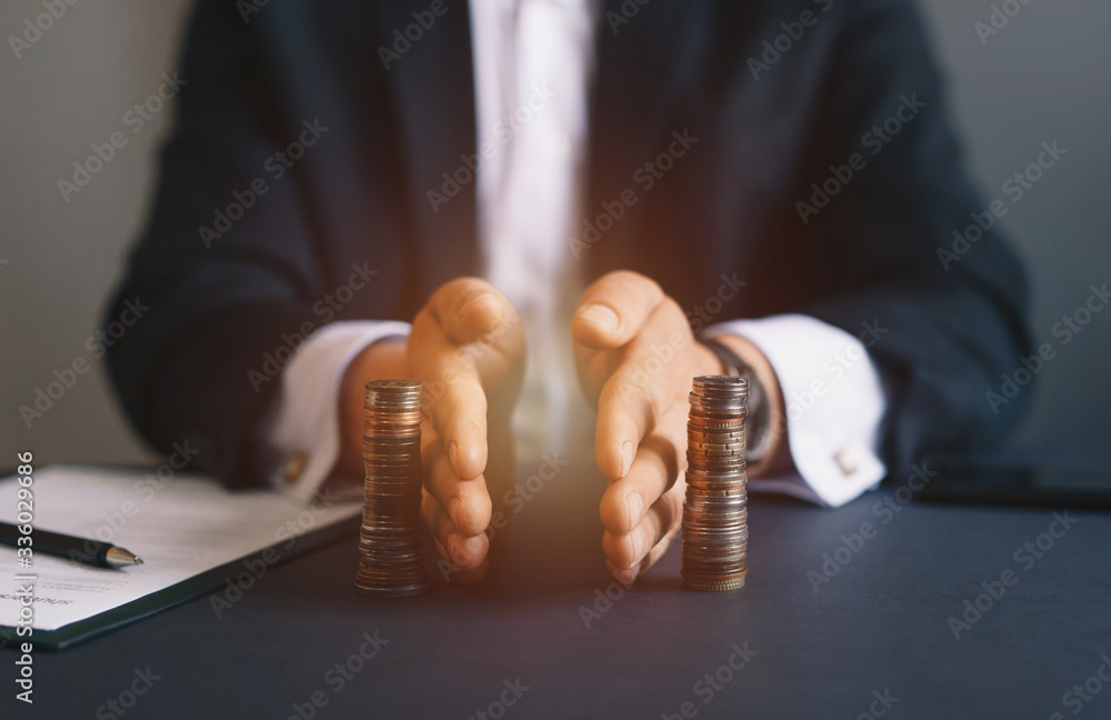 Concept of  saving and investing. Businessman separates stack coins. Property division. Divorce and legal services. - obrazy, fototapety, plakaty 