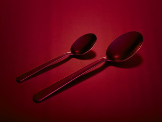 Two tablespoons of dining and dessert on a red beautiful background. You can change the color.