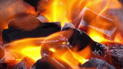 Wall Mural - slow motion speed closeup scene on burning charcoal pile with ash and flake of spark scattered blowi