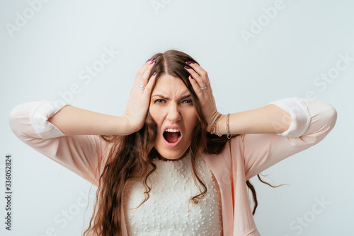 Fotografía long-haired beautiful brunette girl angry and holding his head isolated on white