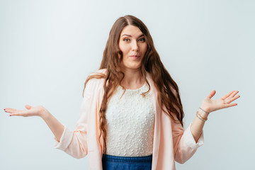 Wall Mural - long-haired beautiful brunette girl does not know what to do and spread her arms to the sides